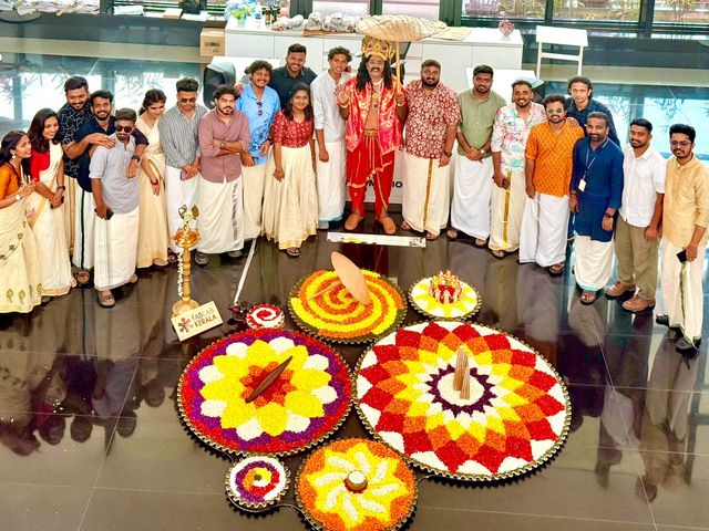 Mahabali with a startup team beside a floor of finished pookalams
